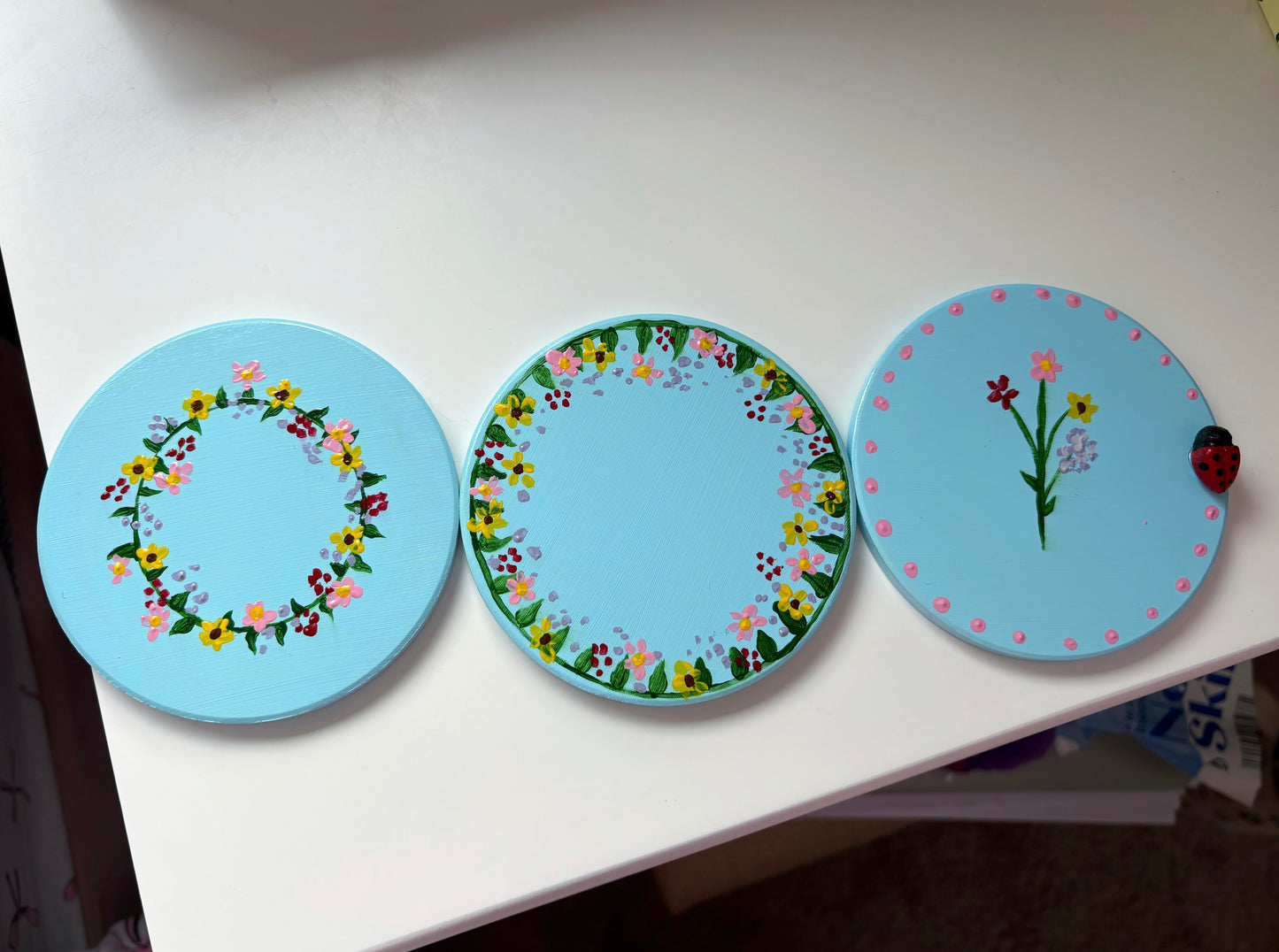 Pastel wildlife coasters, with hand painted wild flowers and a clay ladybug.