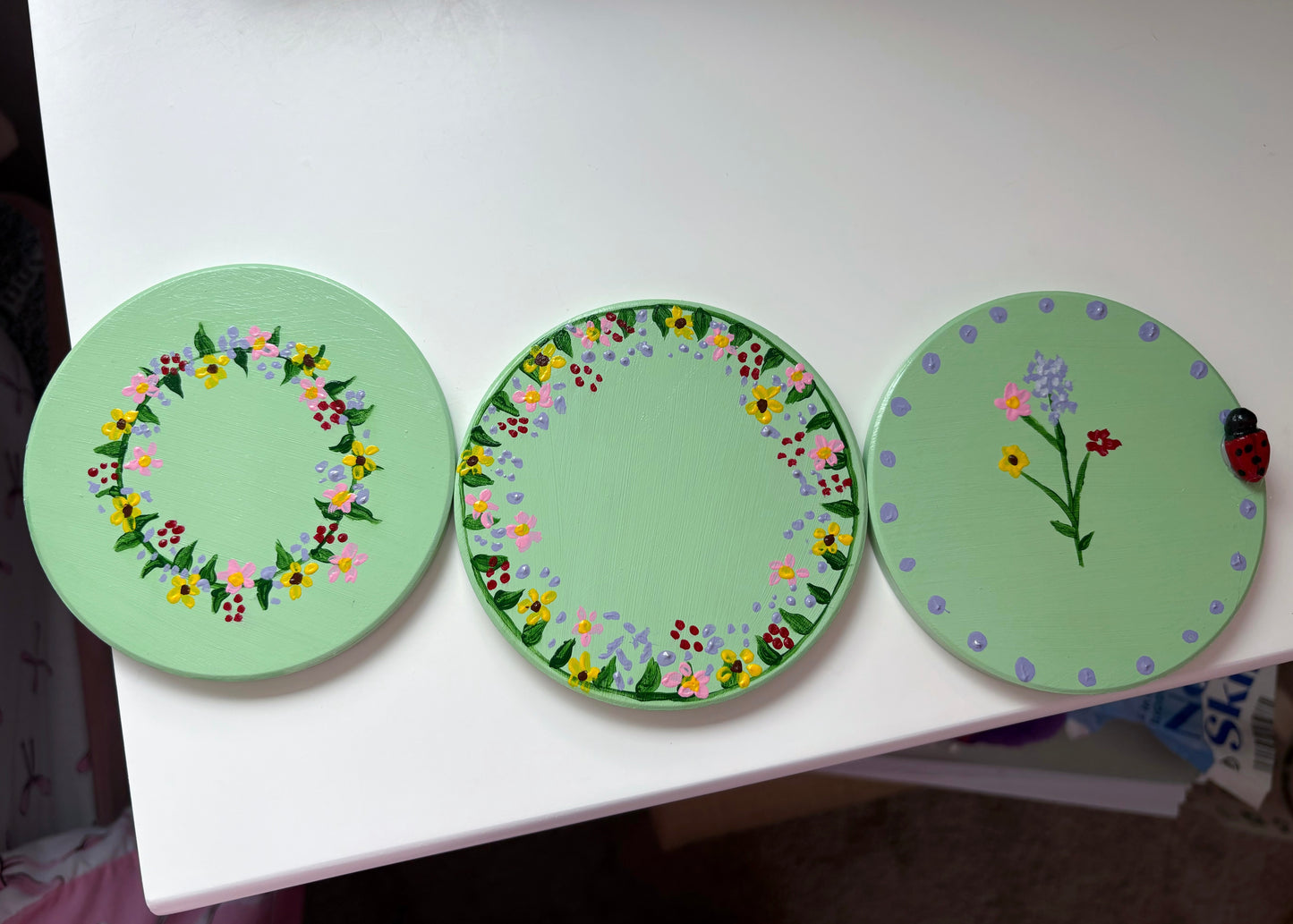 Pastel wildlife coasters, with hand painted wild flowers and a clay ladybug.