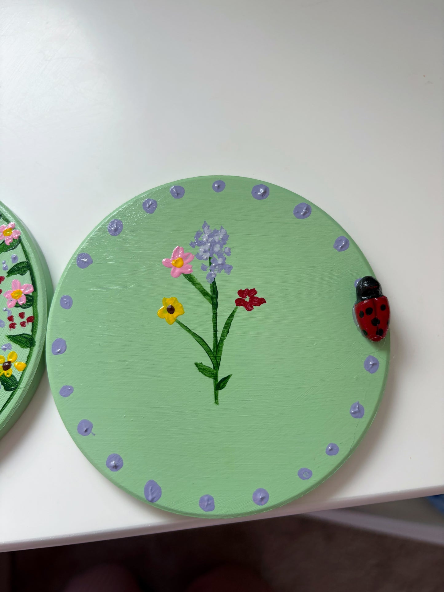 Pastel wildlife coasters, with hand painted wild flowers and a clay ladybug.